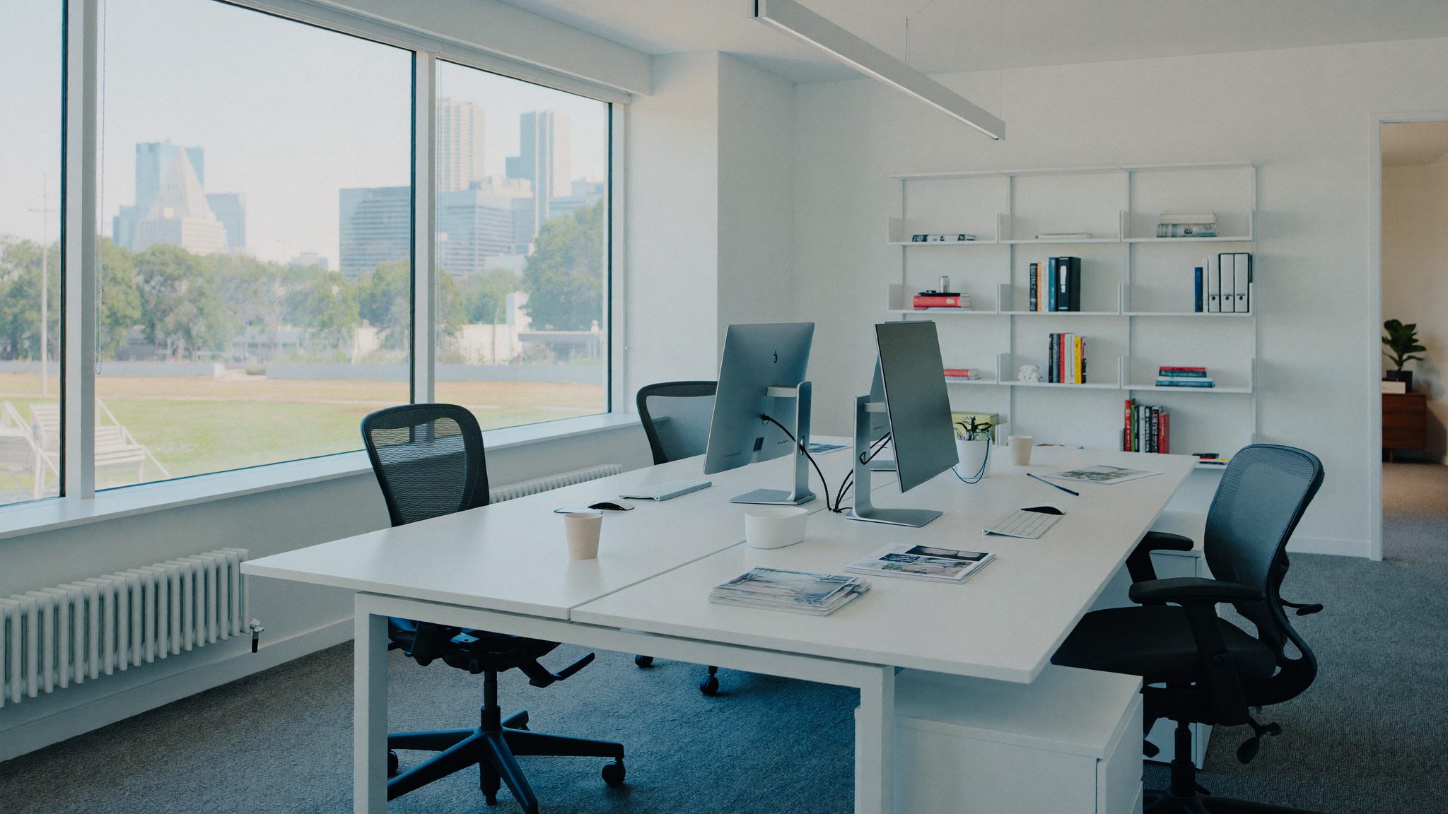 Calm, organised office workspace where Farnesto reviews client numbers